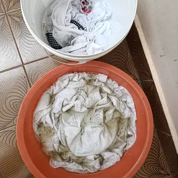 Balde e bacia com roupa branca de molho